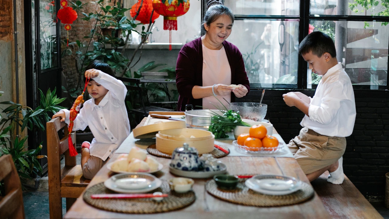 Chinese New Year Cleaning and Pest Prevention Tips for a Fresh Start A woman and two children enjoy a meal together at a table, celebrating the spirit of Chinese New Year with festive food.