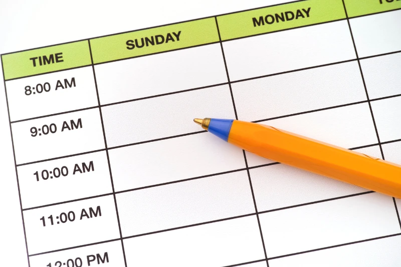 Creating a Maintenance Schedule A pencil is positioned on a weekly planner, representing the organization of home maintenance activities for the week ahead.