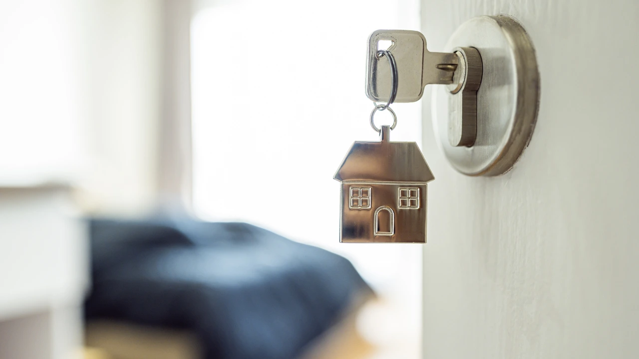 Essential Pest Control Measures for Home Rentals and Airbnb Hosts A close-up of a house key on a door handle, representing home rentals and pest control measures for Airbnb accommodations.