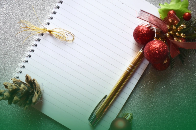 Christmas Shopping and Gift Planningg a notebook with a pen and ornaments