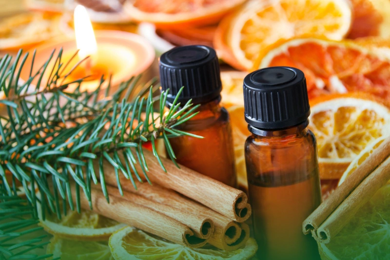 Holiday Scents a group of bottles of essential oils with cinnamon sticks and orange slices