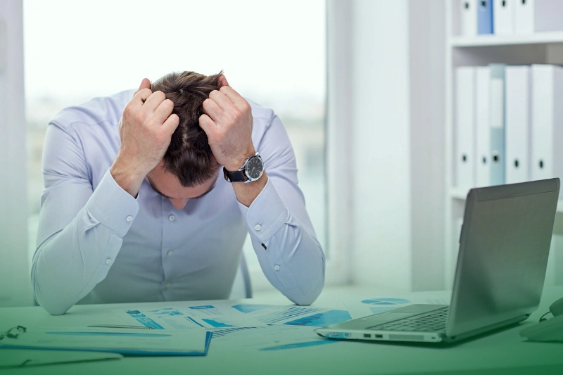 Lost Revenue stressed businessman with papers and charts sitting in an office