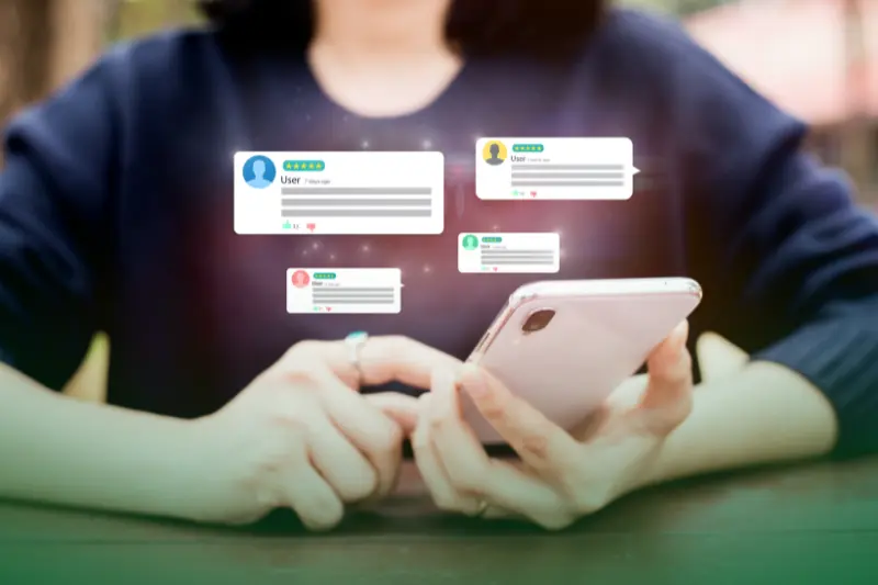 Preventing Negative Customer Experiences a woman holding a phone checking our online reviews