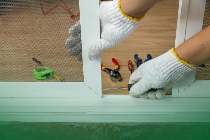 Seal Entry Points worker fixing the insect screen sliding door